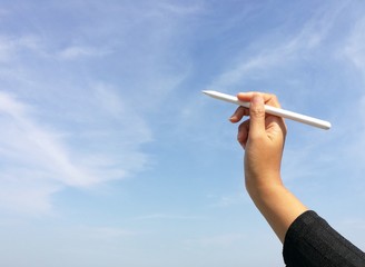 Woman hand holding pen with blue sky blue 