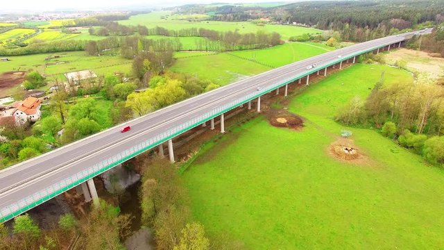 Aerial view of bridge over Radbuza River and green pastures. Highway D5 with traffic near Pilsen, Czech republic, Central Europe. Transportation and sustainable development concept. 