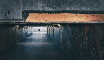 The Passage.  A man walking down an underground passage.