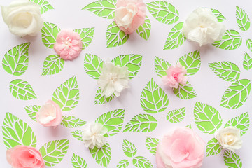 color paper flowers on the background of green leaves
