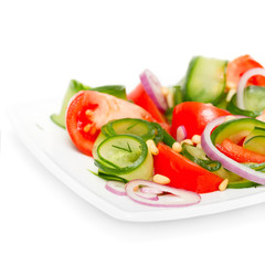 Fresh vegetable salad with pine nuts isolated on white