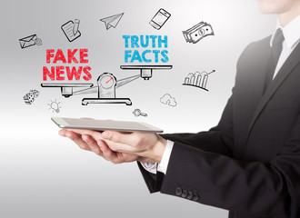 Fake News Infomation concept. Young man holding a tablet computer.