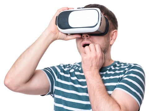 Amazed man wearing virtual reality goggles watching movies or playing video games, isolated on white background. Surprised male worried and scared making face looking in VR glasses.