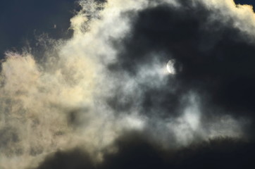 the sun behind the cloud
