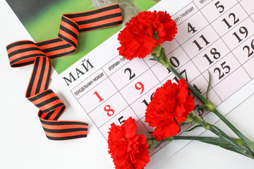 Victory Day. St. George Ribbon. День Победы. Красные гвоздики, календарь и Георгиевская лента.