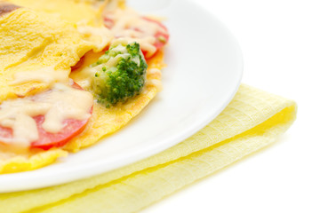 omelet with broccoli, tomatoes and cheese close-up, focus on the broccoli