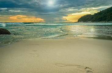 Sunset on the beach against the backdrop of storm clouds