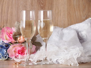 Champagne glasses on wedding dress background and wedding rings
