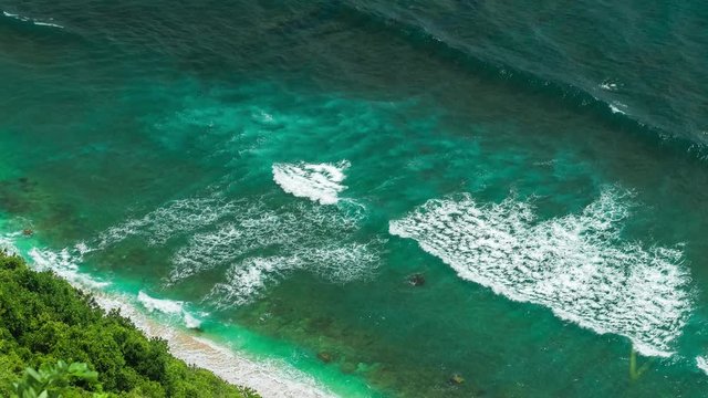 Aerial view of waves rolling one by one to the Nunggalan Beach near Uluwatu, Bali, Indonesia
