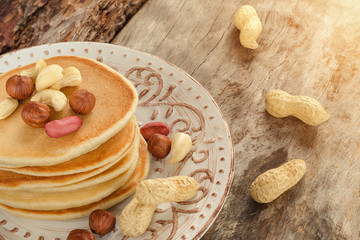 Stack of hot pancakes with nuts on the plate