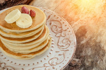Stack of hot pancakes with bananas and nuts.