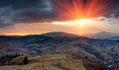 Panoramic landscape in the mountains at sunrise. Dramatic sky with colorful clouds. 