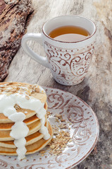 Stack of hot pancakes with oatmeal and yogurt.