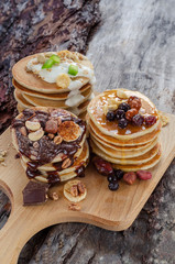 Obraz na płótnie Canvas Three stack of pancakes with chocolate, yogurt and caramel syrup.