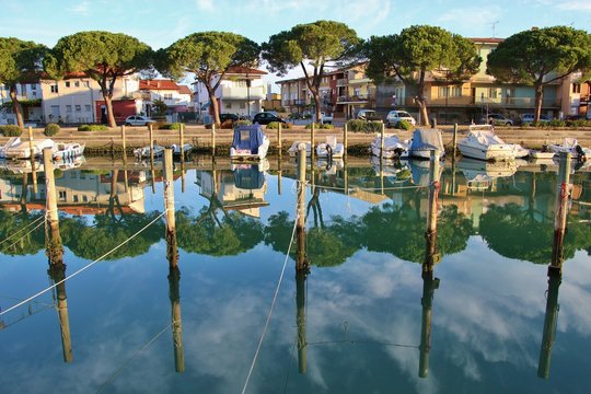 Canal and boats in Grado in bright morning light. North-Eastern Italy, Europe.