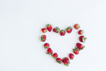 Heart frame of strawberries on white background. Flat lay, top view.