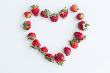 Obraz premium Heart frame of strawberries on white background. Flat lay, top view.