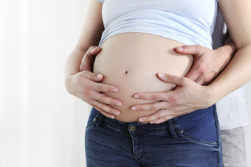 couple hands on the pregnant  belly, concept of pregnancy, expecting a baby, love, care