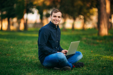 The young manager working on a laptop in the park. Lunch Break.