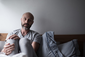 Mid forties depressed man in bed at home