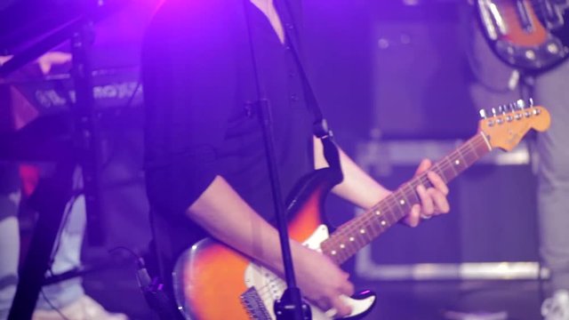 Electric Guitar Player Playing Rock Music at the Concert in the Night Club with Beautiful Light