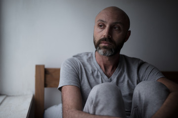 Mid forties depressed man in bed at home