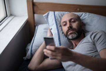 Mid forties depressed man in bed at home