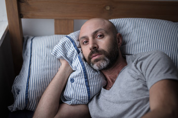 Fototapeta premium Mid forties depressed man in bed at home