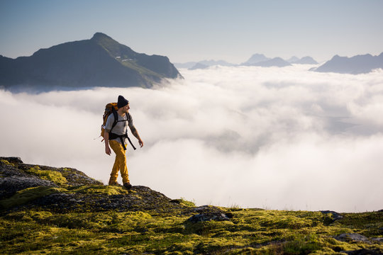 Man trekking high up in the mountains above the clouds 
