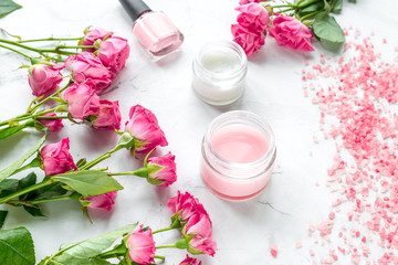 organic cosmetic with rose cream and petals on white background