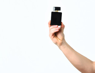 Strong male hand with bottle of perfume on wooden bench