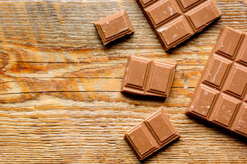 chopped chocolate pieces for dessert wooden desk background top view space for text