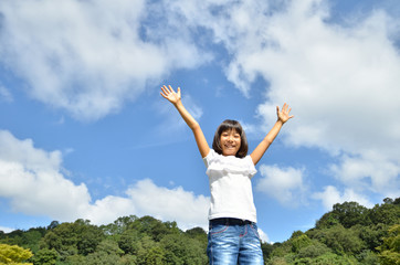 青空でバンザイする女の子