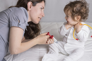 Baby playing a doctor with mother