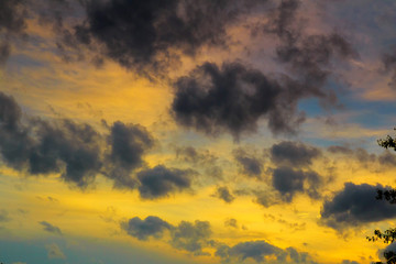 Cumulus sunset clouds with sun setting down