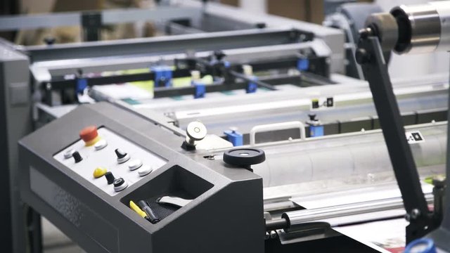 Close up of an industrial printer working at a printing plant. Locked down real time close up shot