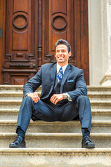 Middle Age American Businessman sitting on stairs outside vintage office in New York, taking work break, thinking