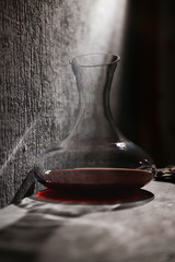 Glass carafe of wine on table against gray background