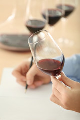 Sommelier estimating red wine in wineglass at tasting