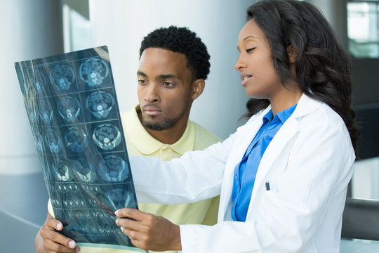 Closeup portrait of intellectual healthcare professionals with white labcoat, looking at full body x-ray radiographic image, ct scan, mri, isolated hospital clinic background. Radiology department