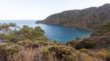 Obraz premium Cove in the clear sea on the background of the rocky mountains
