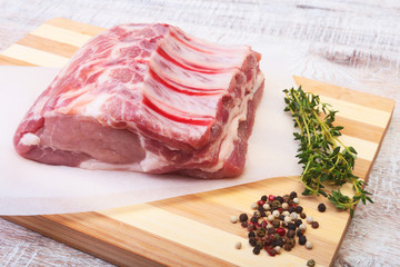 Raw pork chops, spices and rosemary on cutting board. Ready for cooking.