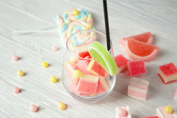 Composition with tasty candies on light wooden background