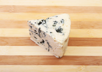Plate with Tasty blue cheese on wooden table