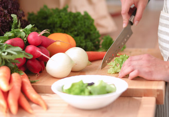 Young woman cutting vegetables in the kitchen