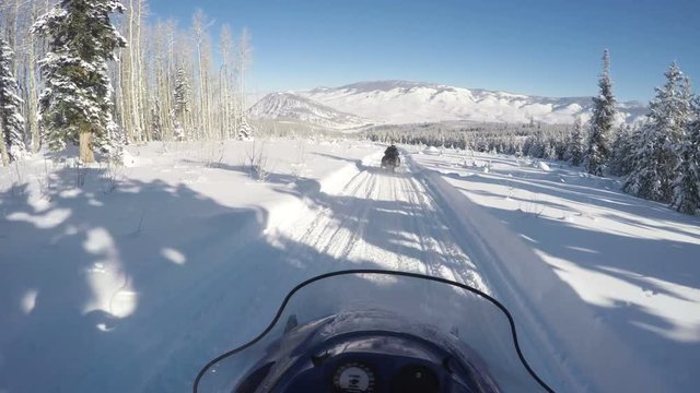 Snowmobile follows guide through beautiful mountains