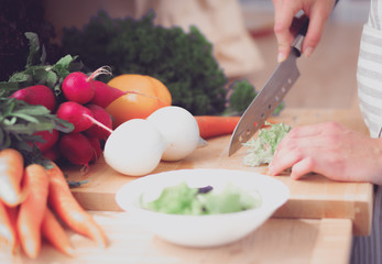 Young woman cutting vegetables in the kitchen