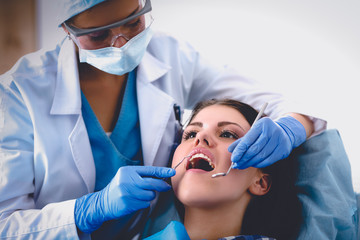 Woman dentist working at her patients teeth