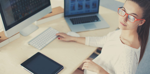 Young woman working in office, sitting at desk