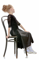 Fototapeta premium Slender little dancer posing near the old Vienna chair.